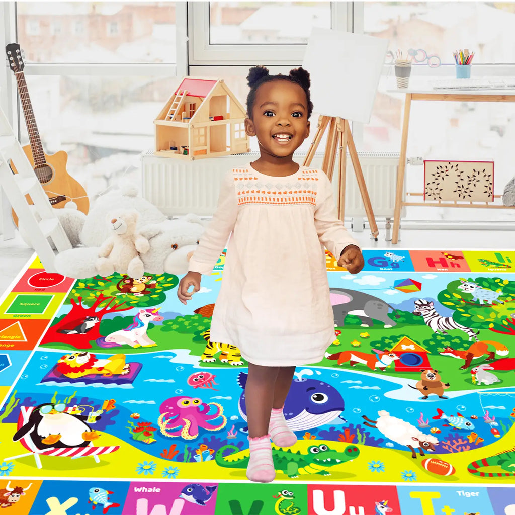 Toddler standing and smiling on the Deluxe ABC Baby Play Mat — bright educational alphabet floor rug with animals, colors, and letters for kids’ learning play.
